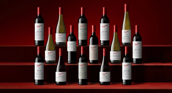 Different bottles of red and white Penfold's Wine stacked in three rows